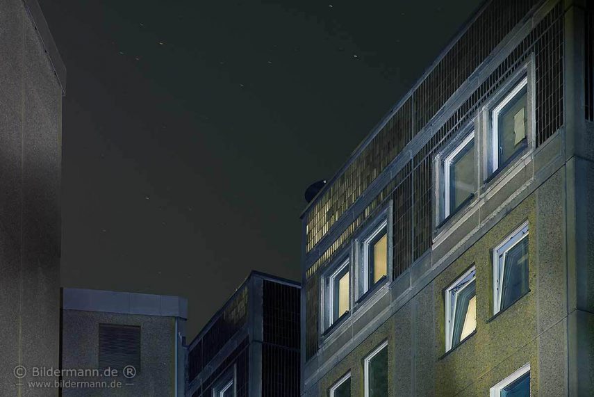 Foto: In der Hausfassade eines Wohnblockes spiegelt sich das Vollmondlicht